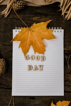 Hands and White blank notebook with wooden letters phrase Good day on a dark  Stock Photos