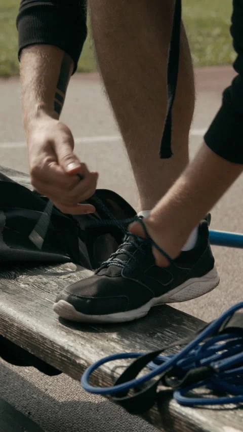 Hands of Anonymous Para Athlete Tying Shoelaces at Stadium Video stock 299110804