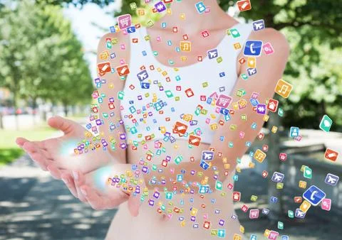 Hands with application icons coming up form it. Blurred park background Fotos de archivo