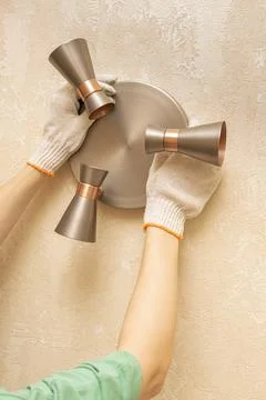 Hands apply the lamp to the wall before installation Stock Photos