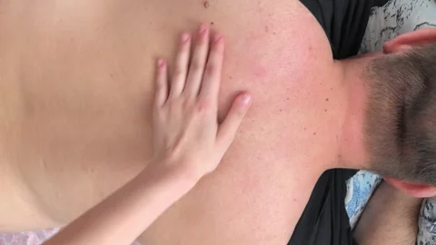 Hands apply pressure on back for massage therapy at a wellness center in the Stock Footage 328980415