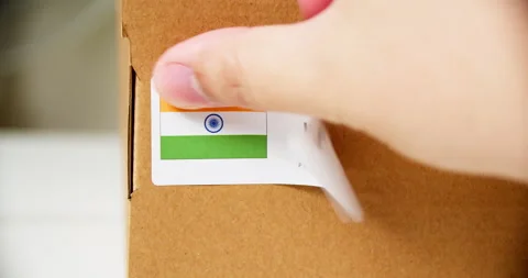 Hands applying MADE IN INDIA  flag label on a shipping cardboard box with Stock Footage 199009205