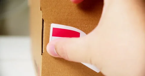 Hands applying MADE IN INDONESIA  flag label on a shipping cardboard box Stock Footage 199041930