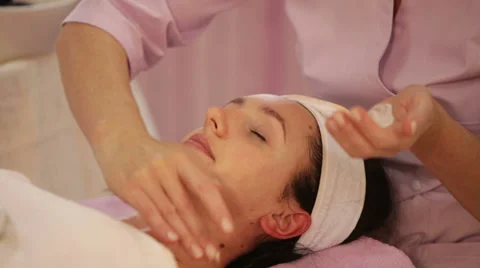 Hands applying moisturizer on woman's face before massaging it Stock Footage 35826444