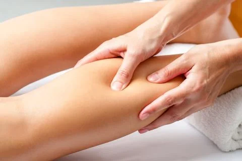 Hands applying pressure with fingers on calf muscle. Stock Photos