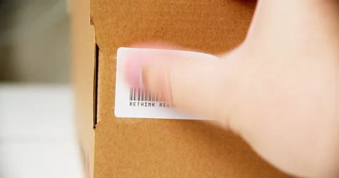 Hands applying RECYCLE Sticker label on a cardboard box with barcode Stock Footage 200092736