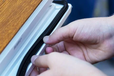 Hands applying strip. insulation of windows, door Stock Photos