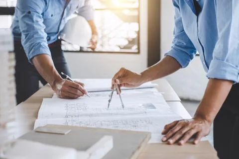 Hands of architect or engineer working on blueprint meeting for project worki Stock Photos