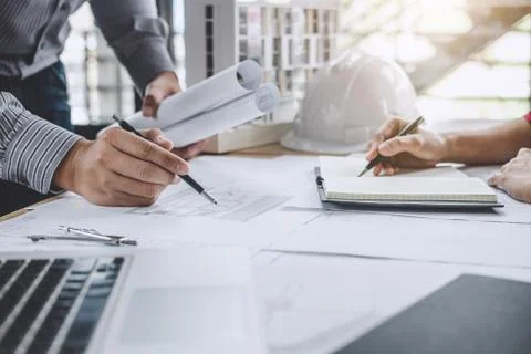 Hands of architect or engineer working on blueprint meeting for project worki Stock Photos