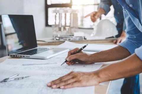 Hands of architect or engineer working on blueprint meeting for project worki Stock Photos