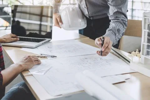Hands of architect or engineer working on blueprint meeting for project worki Stock Photos