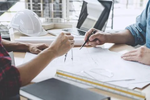 Hands of architect or engineer working on blueprint meeting for project worki Stock Photos