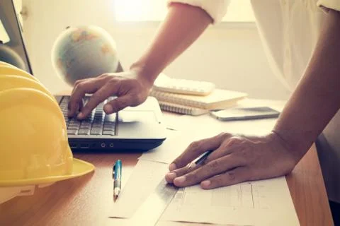 Hands of architect working on laptop with construction plan Stock Photos