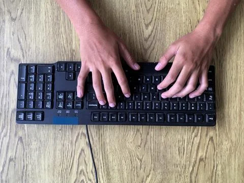 Hands are actively typing on a computer or laptop keyboard, daily work activity Stock Photos