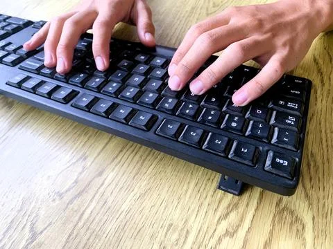Hands are actively typing on a computer or laptop keyboard, daily work activity Stock Photos