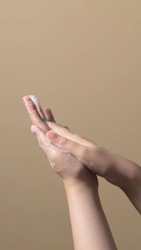 Hands are being cleaned using soap on beige background Stock Footage 304212952