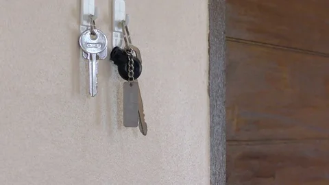 Hands that are going to take keys from a house hung on a hook in the wall Stock Footage 82309030