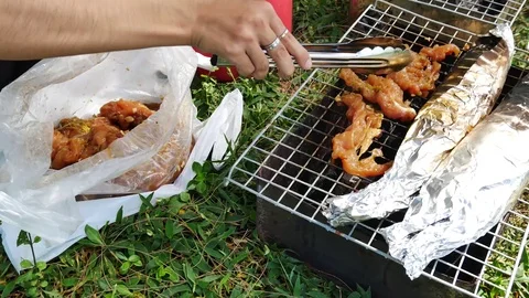 The hands are grilled Seafood grill or  barbecue with charcoal in the party. Vídeo Stock 70153485