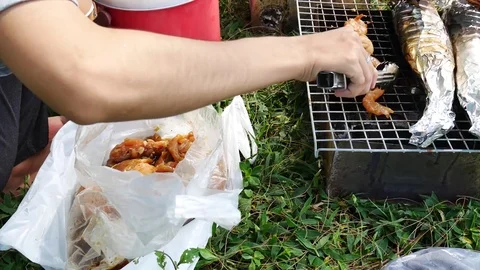 The hands are grilled Seafood grill or  barbecue with charcoal in the party. Video stock 70153503