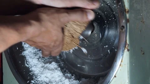 Hands are grinding coconut using a coconut machine at home Stock Footage 127735118