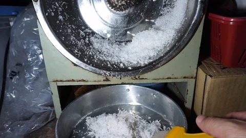 Hands are grinding coconut using a coconut machine at home Stock Footage 127762097