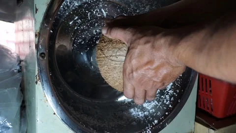 Hands are grinding coconut using a coconut machine at home Stock Footage 127805273