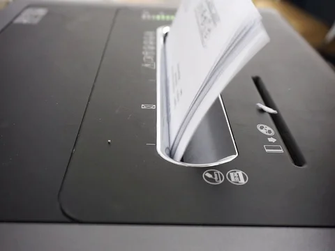 Hands are inserting office documents for disposal into shredder machines Stock Footage 86716907