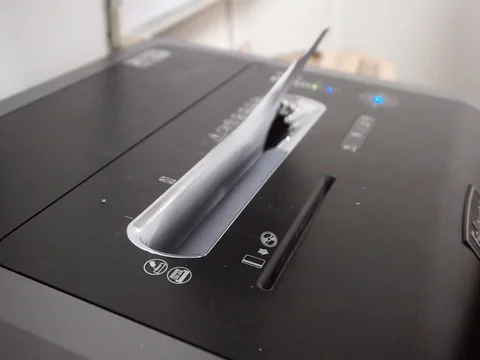 Hands are inserting office documents for disposal into shredder machines Stock Footage 86717023