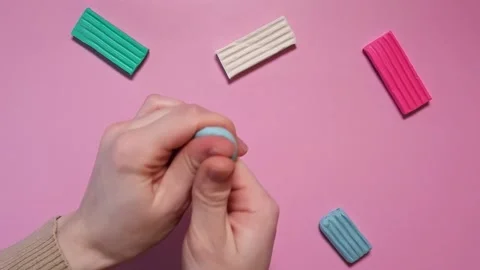 Hands are modeling from blue plasticine. Hands crumple a piece of plasticine. Stock Footage 167538809