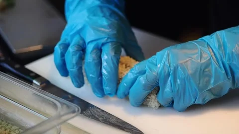 Hands are preparing sushi rolls in a kitchen with tools on the table Stock Footage 340122832