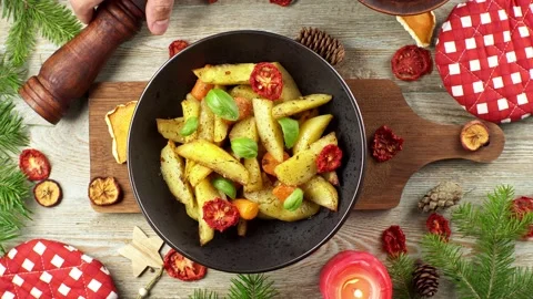 Hands are putting an appetizing potatoes dish and sprinkling spices Stock Footage 196225553