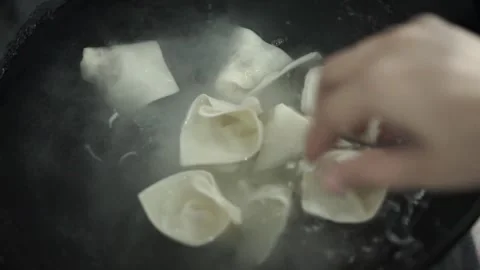 Hands are putting dumplings in to be boiled Stock Footage 261247995