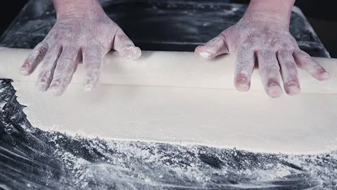 Hands are rolling out the dough with a rolling pin Stock Footage 140182445