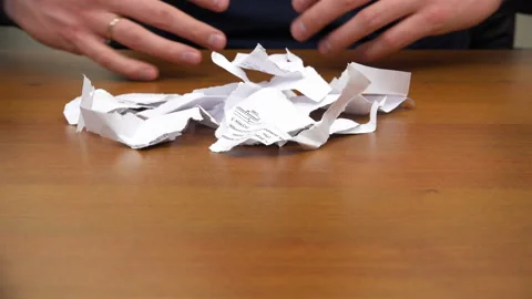 Hands are rowing away torn documents and showing fists with a cookie Stock Footage 99941938