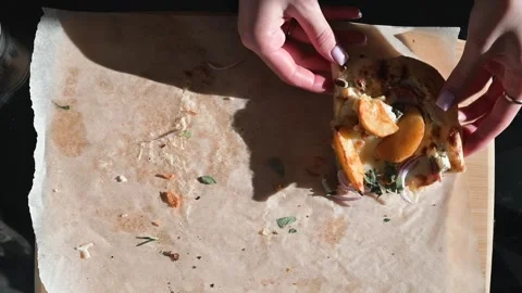 Hands are seen assembling a pastry on parchment paper placed on a wooden surface Stockbeeldmateriaal 337556273