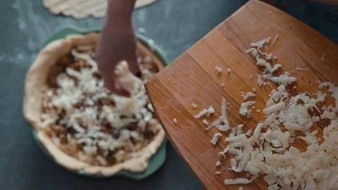 Hands are seen chopping cheese and mixing them into a pie crust Stock Footage 339094574