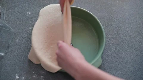 Hands are seen shaping dough to fit a pie dish in a kitchen setting. The action Vidéo 339094486
