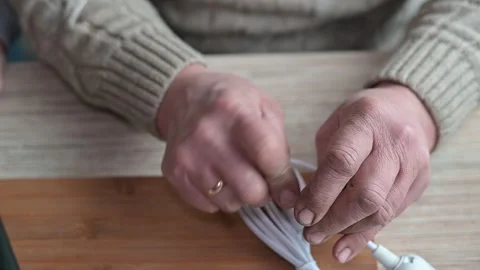 Hands are seen working with an electronic device cable. The person secures 库存影片 337111191