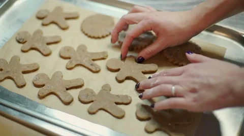The hands are setting down the ginger boys on the sheet tray Stock Footage 57497740