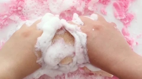 Hands are shaking a washcloth in soapy pink foam.. Asmr. Part 9 Stock Footage 293733837