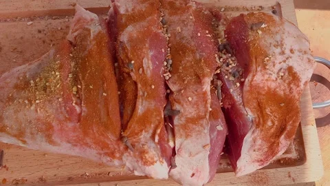 Hands are stuffing a raw meat leg with spices on the wooden board Stock Footage 279730672