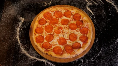 Hands are taking slices of pepperoni pizza away from the wooden board. Stock Footage 132769981