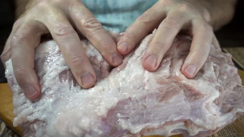 The hands are touching a piece of raw meat in slow motion. Stock Footage 135755658
