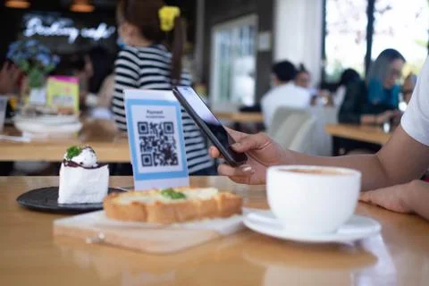 Hands are using  the phone to scan the qr code to select food menu. Scan to g Stock Photos