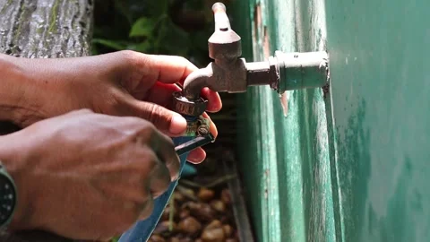 Hands are using screwdriver to loosen clamp for remove rubber hose Stock Footage 147139202