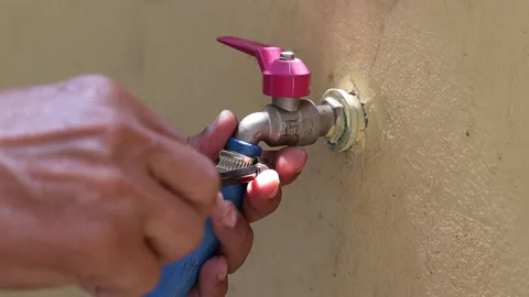 Hands are using screwdriver to loosen clamp for remove blue rubber hose Stock Footage 147140199