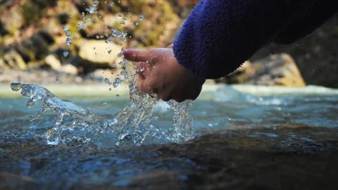 Hands are washed in a mountain river close-up Stock Footage 270458960