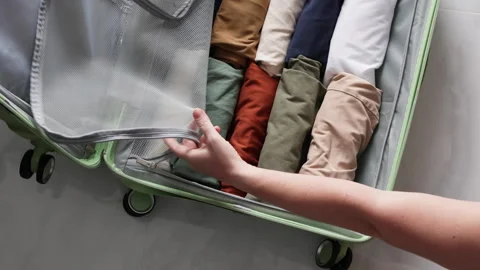 Hands arrange clothing in rows inside the suitcase Stock Footage 311903562