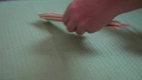 Hands arranging bamboo chopsticks on a table Stock Footage 69784705