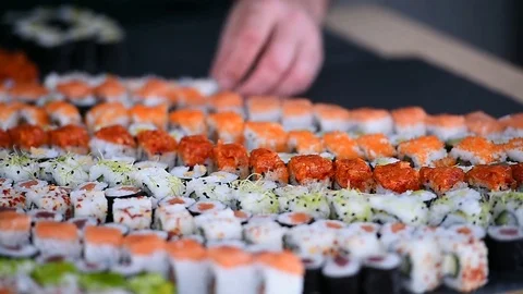 Hands arranging different sushi appetizers on a plate Stock Footage 72388032